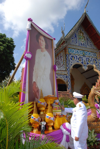 ประธานในพิธี ถวายความเคารพพระฉายาลักษณ์หน้าอุโบสถ แล้วถือผ้าไตรพระราชทาน และถวายความเคารพ