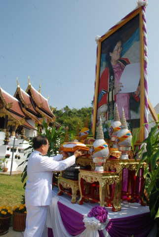ประธานในพิธี ถวายความเคารพพระฉายาลักษณ์หน้าอุโบสถ แล้วถือผ้าไตรพระราชทาน และถวายความเคารพ