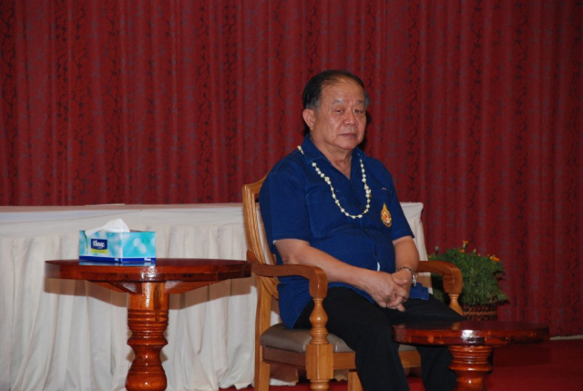 รศ.ดร.วันชัย ศิริชนะ อธิการบดี เดินขึ้นเวที และนั่งเก้าอี้ที่จัดไว้