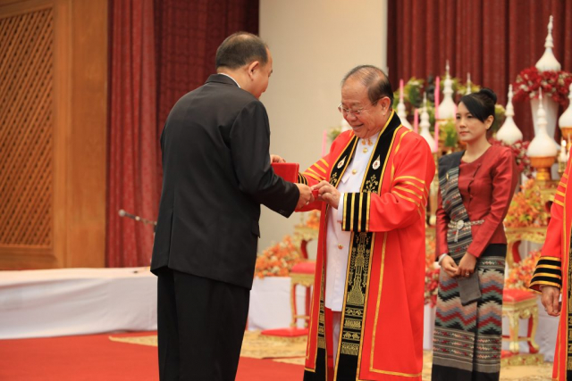 ดร.ประชา รุ่งเพ็ชรวิภาวดี สมาคมนักศึกษาเก่ามหาวิทยาลัยแม่ฟ้าหลวง มอบเข็มกลัดที่ระลึกแก่ รศ.ดร.วันชัย ศิริชนะ อธิการบดีผู้ก่อตั้ง