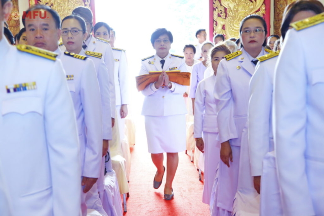 รศ.ดร.ชยาพร วัฒนศิริ ประธานในพิธีเดินเข้าสู่อุโบสถ