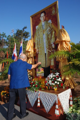 พลตำรวจเอก เภา สารสิน ประธานในพิธี เปิดกรวยดอกไม้สด หน้าพระบรมฉายาลักษณ์พระบาทสมเด็จพระเจ้าอยู่หัวฯ รัชกาลที่ 9
