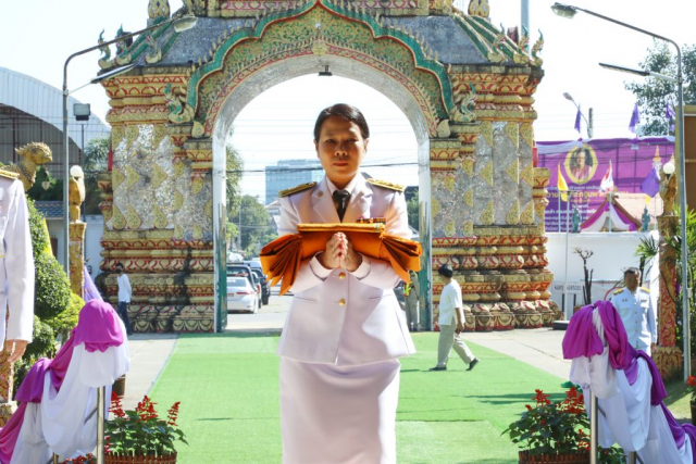 ผู้ช่วยศาสตราจารย์ ดร.มัชฌิมา นราดิศร อธิการบดีมหาวิทยาลัยแม่ฟ้าหลวง ประธานในพิธี ถือผ้าพระกฐินพระราชทานอุ้มประคองและเดินเข้าอุโบสถ