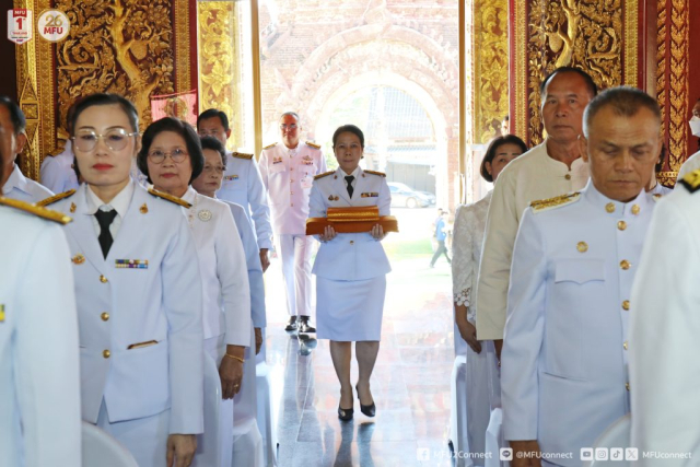 ผู้ช่วยศาสตราจารย์ ดร.มัชฌิมา นราดิศร อธิการบดีมหาวิทยาลัยแม่ฟ้าหลวง ประธานในพิธี ถือผ้าพระกฐินพระราชทานอุ้มประคองและเดินเข้าอุโบสถ