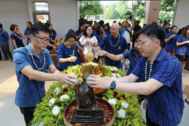 ผู้เข้าร่วมพิธี สรงน้ำพระพุทธรูปพระเจ้าล้านทองเฉลิมพระเกียรติฯ และพระรูปสมเด็จพระศรีนครินทราบรมราชชนนี (จำลอง) บริเวณโถงทางเข้าหอประชุมสมเด็จย่า