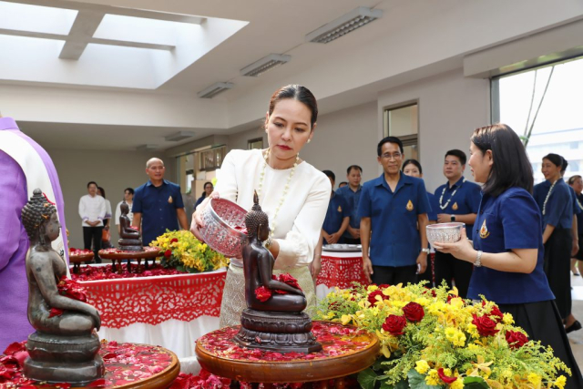 นางสาวสุธาทิพ ยุทธโยธิน ผู้พิพากษาหัวหน้าศาลจังหวัดเชียงราย สรงน้ำพระพุทธรูปพระเจ้าล้านทองเฉลิมพระเกียรติฯ และพระรูปสมเด็จพระศรีนครินทราบรมราชชนนี (จำลอง) บริเวณโถงทางเข้าหอประชุมสมเด็จย่า