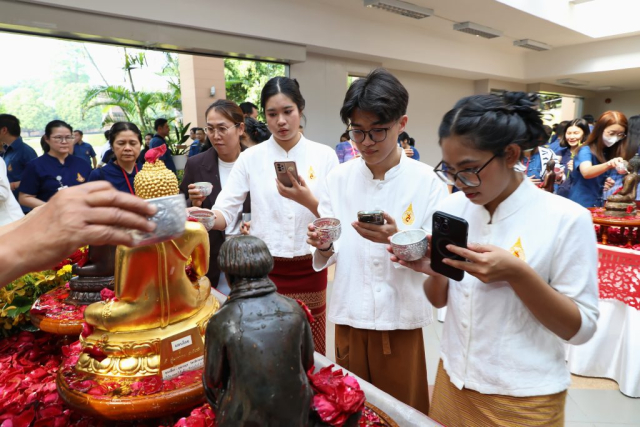 ผู้เข้าร่วมพิธี สรงน้ำพระพุทธรูปพระเจ้าล้านทองเฉลิมพระเกียรติฯ และพระรูปสมเด็จพระศรีนครินทราบรมราชชนนี (จำลอง) บริเวณโถงทางเข้าหอประชุมสมเด็จย่า